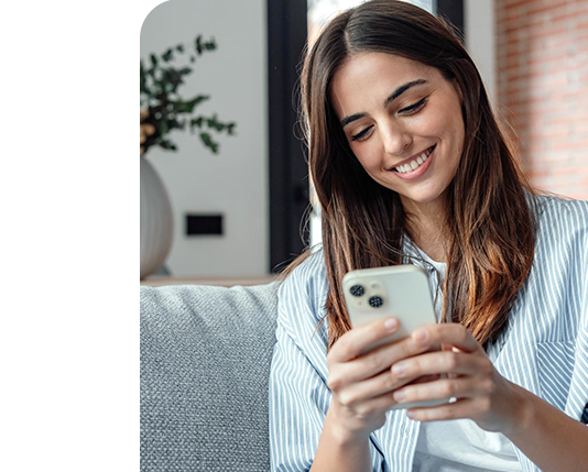 mulher sorrindo mostrando o celular com uma lista de produtos