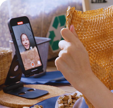 mulher sorrindo mostrando o celular com uma lista de produtos