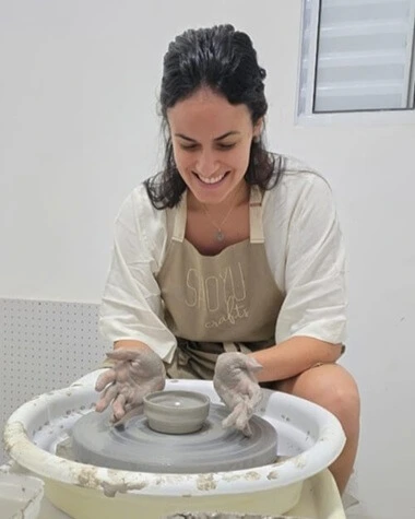 Aluna modelando peça de argila no torno elétrico em aula experimental do ateliê Shoyu Crafts