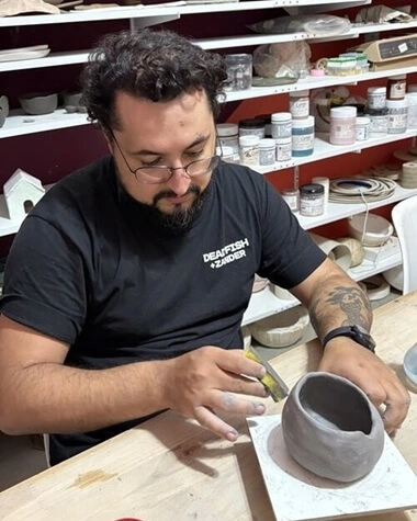 Aluno modelando peça em argila em aula do ateliê Shoyu Crafts